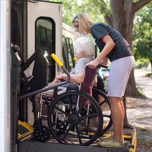 woman pushing an elderly woman in a wheelchair