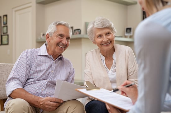 senior couple smiling and talking with financial planner