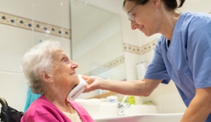 nurse helping older women wash face