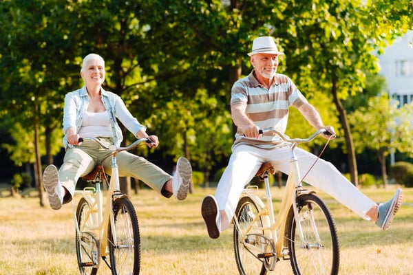 older couple riding bike and taking their feet off the pedals