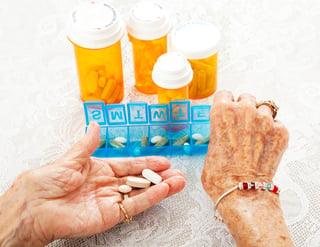 Senior placing pills into a container