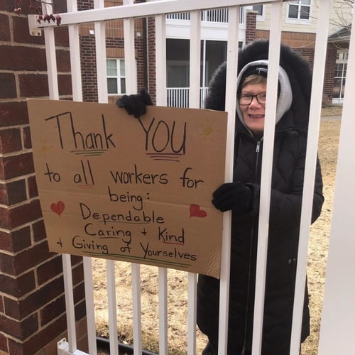 Woman holding a sign saying Thank You to Highview Hills workers