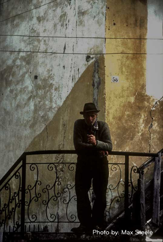 Photo of man in hat standing on staircase